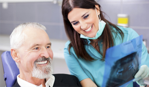 Happy man in a dental chair with his hygienist