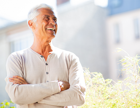 Man outside smiling with arms folded