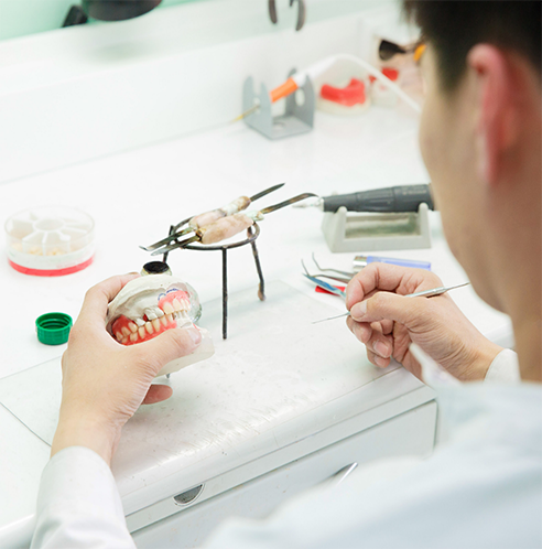 Dental lab technician working on dentures
