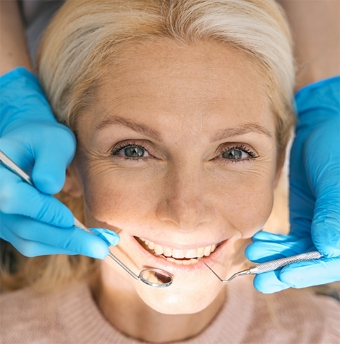 Older female patient having teeth examined