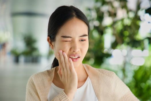 Woman rubbing her aching jaw