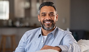 man smiling and sitting on a couch