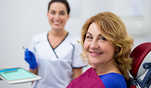 patient smiling with the dental assistant in the background