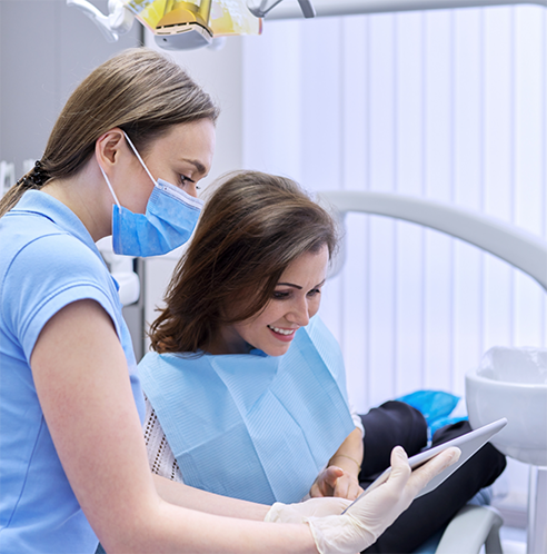 Dentist showing female patient a tablet