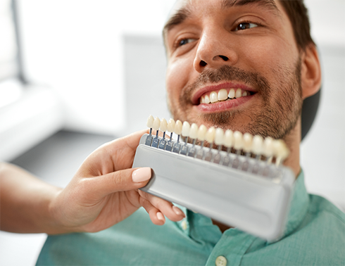 Male dental patient having teeth shade matched for a dental crown