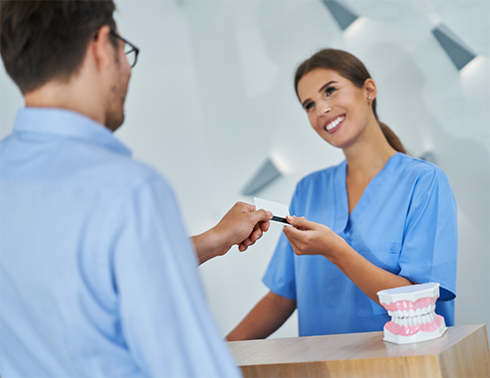 Handing credit card to a dental team member