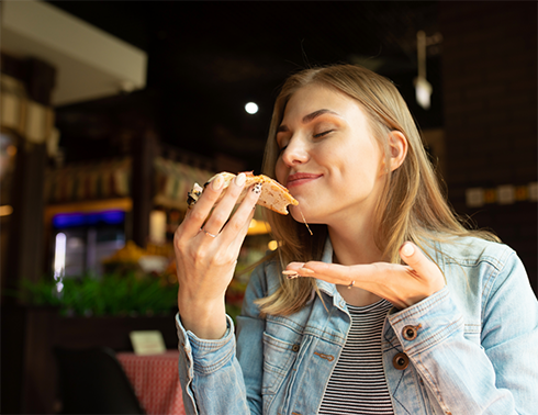 Woman eating a piece of chicken