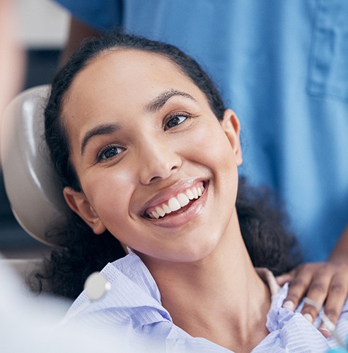 smiling dental patient in front of blue scrubs