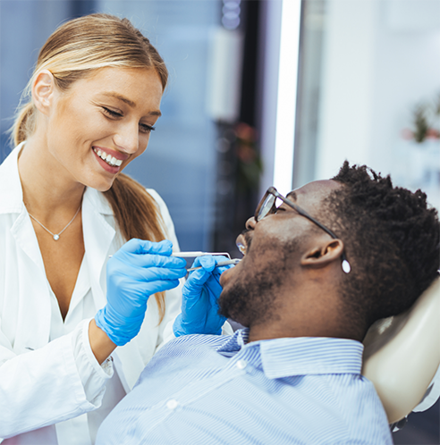 Female dentist performing gum disease treatment in Midland on male patient
