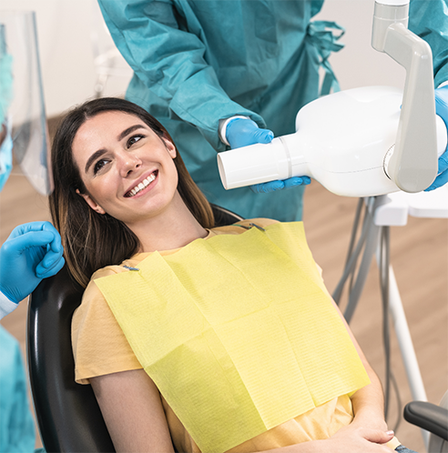 Female patient lying back in dental chair and smiling
