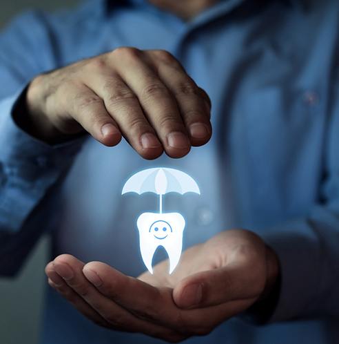 illustration of a tooth with an umbrella between a patient’s hands