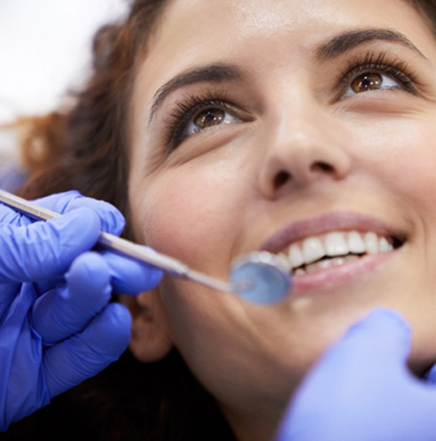 smiling patient having her teeth examined