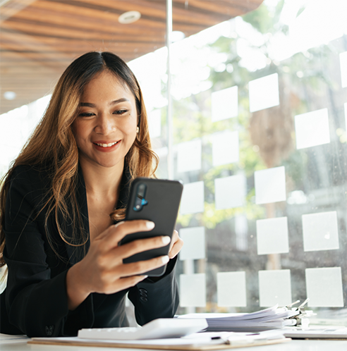 Woman sitting at table looking at phone