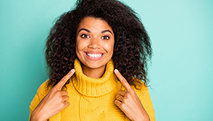 happy woman who prevents dental emergencies in Midland