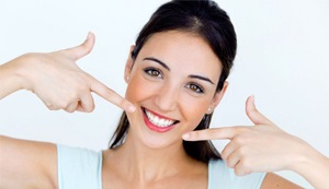 Woman pointing at her beautiful smile.