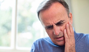 man with jaw pain from teeth clenching