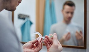 man inserting whitening gel in take-home whitening trays