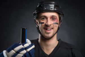 a male hockey player donning his sports attire, complete with a knocked-out tooth