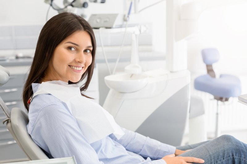 A young woman sitting in the dentist’s chair and smiling 