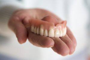 hand holding a denture