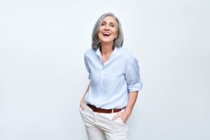 smiling woman after replacing her missing back tooth