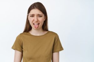 woman sticking out her tongue because of a bitter taste in her mouth