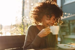 woman drinking coffee with porcelain veneers