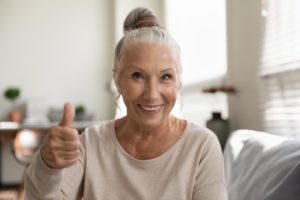 older woman smiling after working with a cosmetic dentist