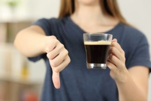 woman holding coffee showing foods and drinks to avoid after teeth whitening