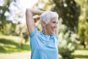 woman stretching outside showing how exercise may prevent gum disease