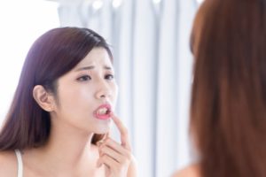 concerned woman looking at her teeth