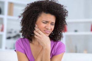 woman holding her face with jaw pain