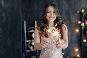 smiling woman holding sparklers