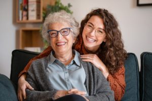 elderly woman and her granddaughter smiling together