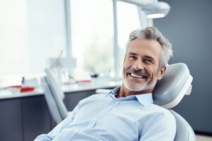 smiling man in the dental chair with his new dentures