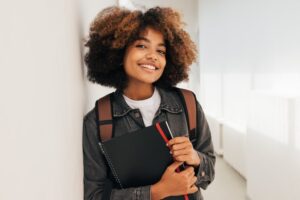 smiling student holding a backpack