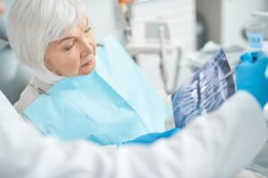 older woman at consultation looking at X-rays with dentist